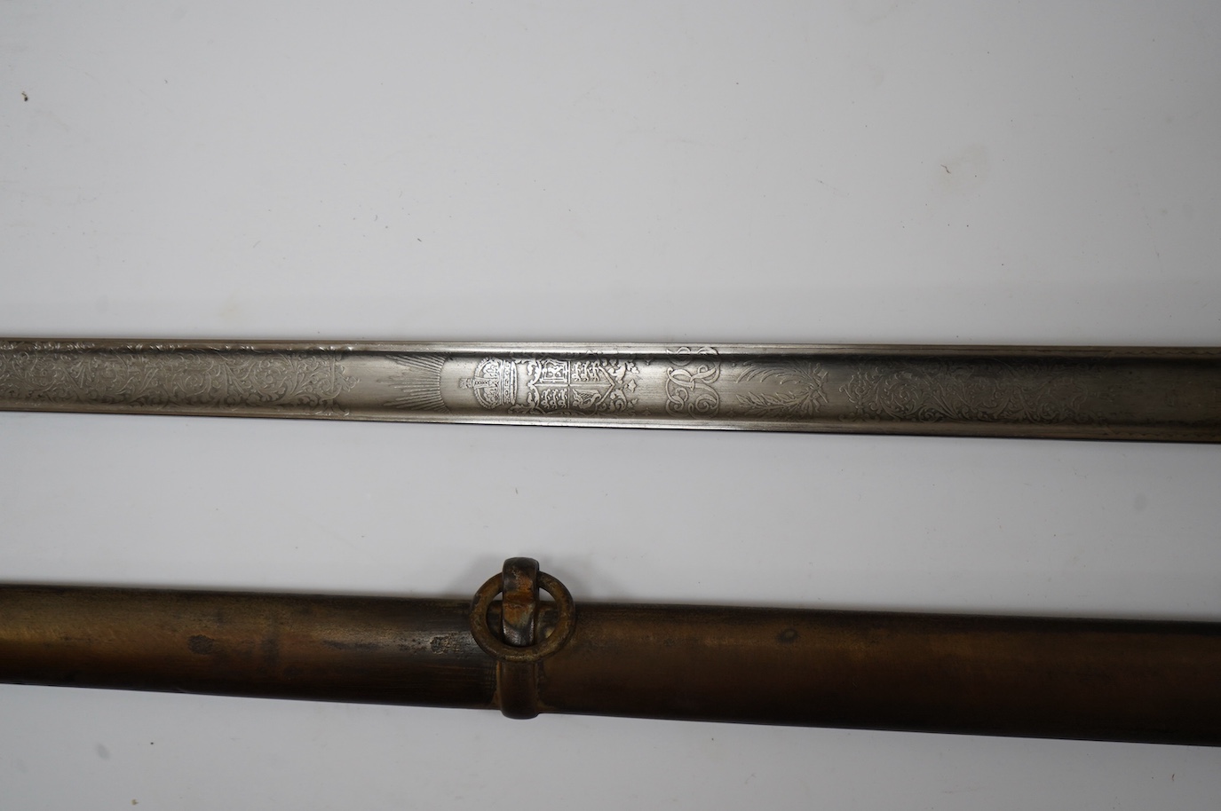 An Edward VII 1897 pattern infantry officer’s sword by Wilkinson, number 40202, blade etched with regulation designs and owners initials; KDA, regulation guard in its steel scabbard. Condition - fair, scabbard badly dent